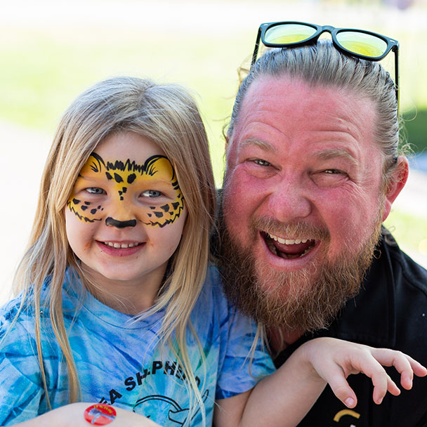 Child and dad with free facepainting at the Education Fair 2023