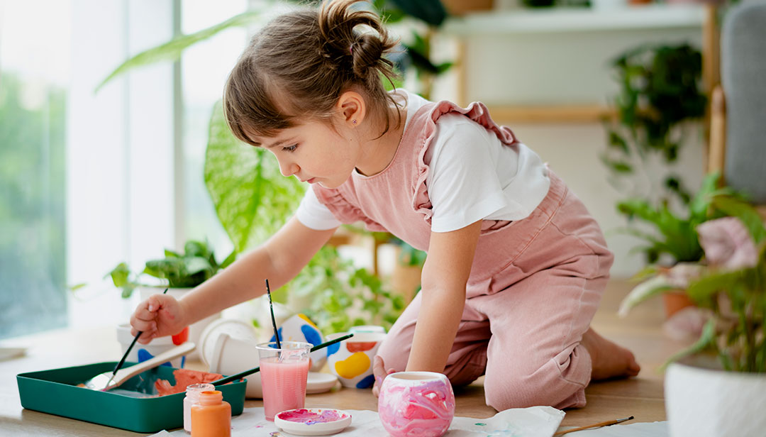 little girl painting and exploring childhood creativity